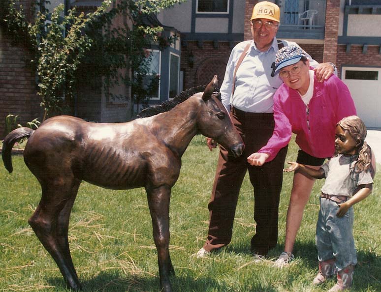 Mr. and Mrs. Louis Bell with child and horse sculpture